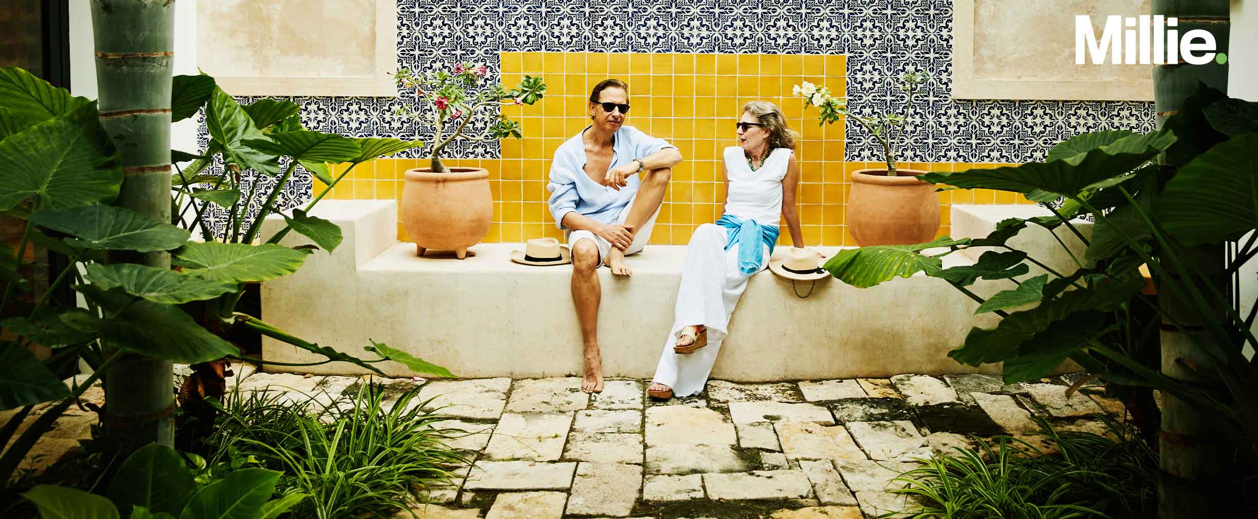 A happily retired couple lounging in the outdoor area of their home abroad.