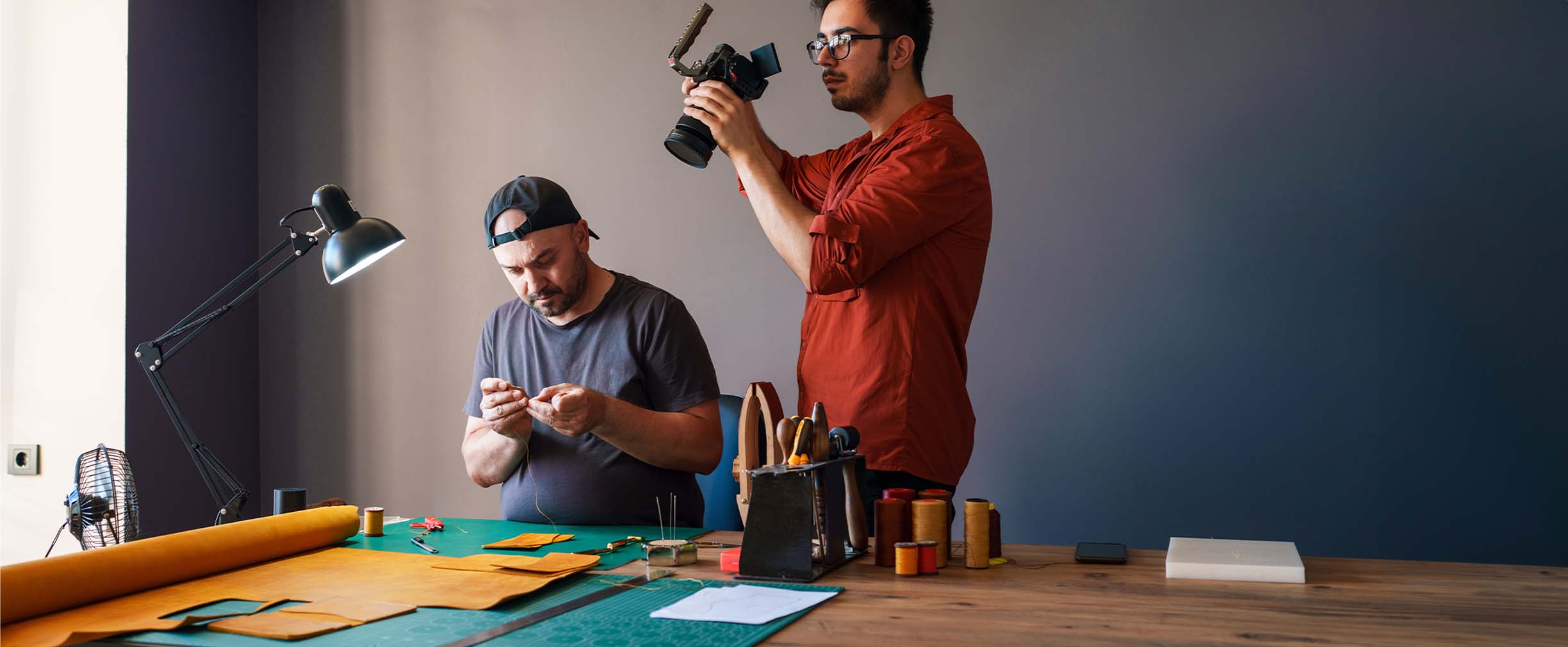 Dos artistas trabajan en la creación de un pequeño video en un escritorio con muy pocas herramientas