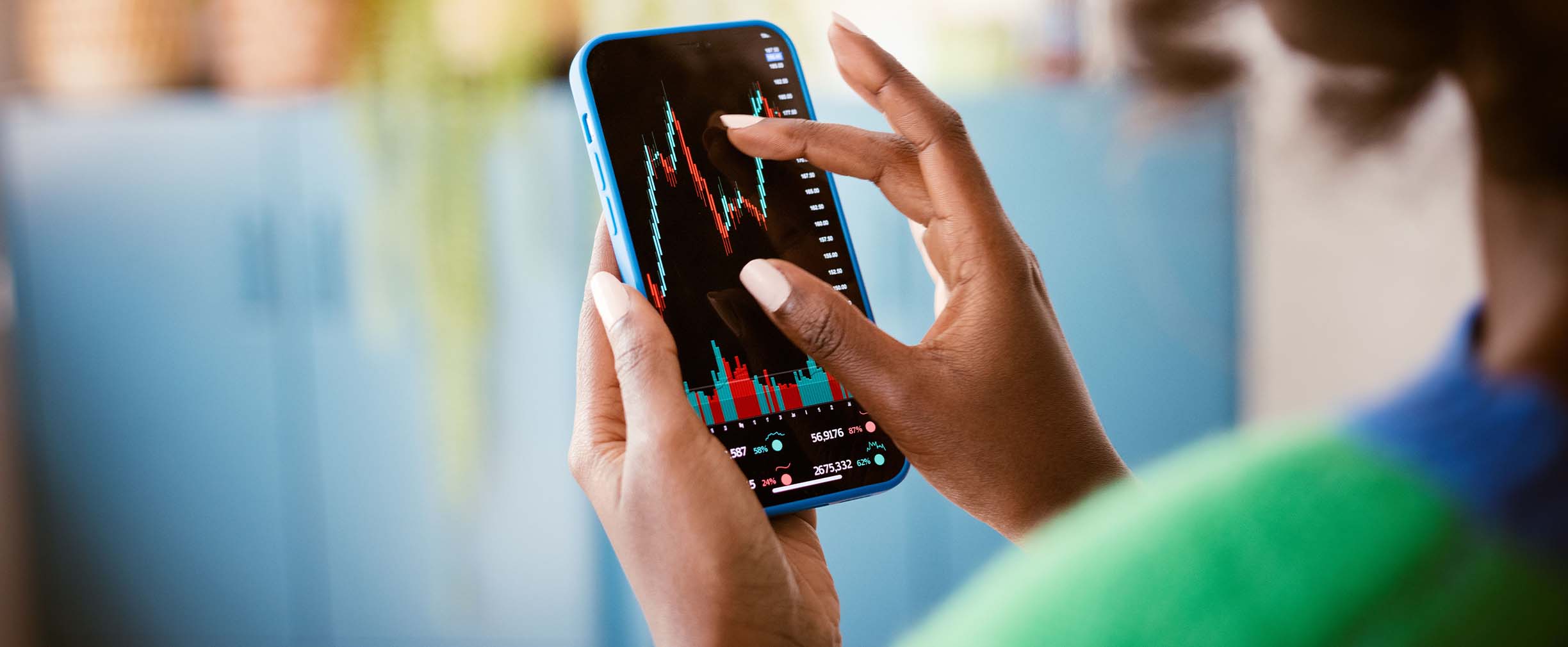 Fotografía de cerca de una mujer que revisa el valor fluctuante de los bienes en su smartphone.